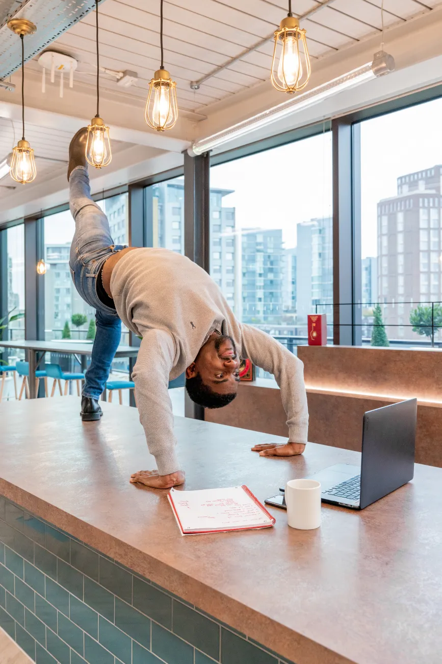 A staff member at Four striking a complex pose in the office to illustrate the concept of flexible working