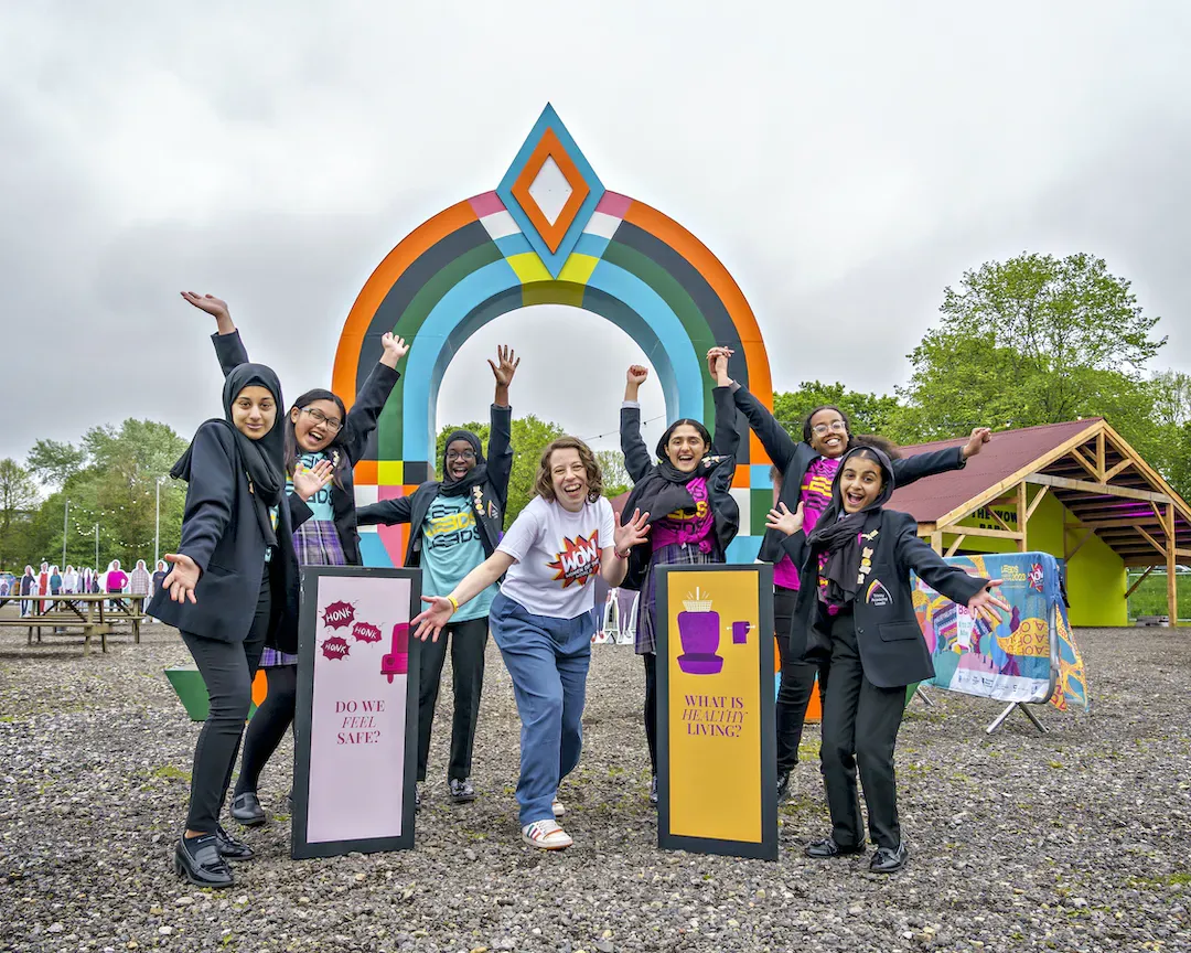 Women standing in front of a colourful banner