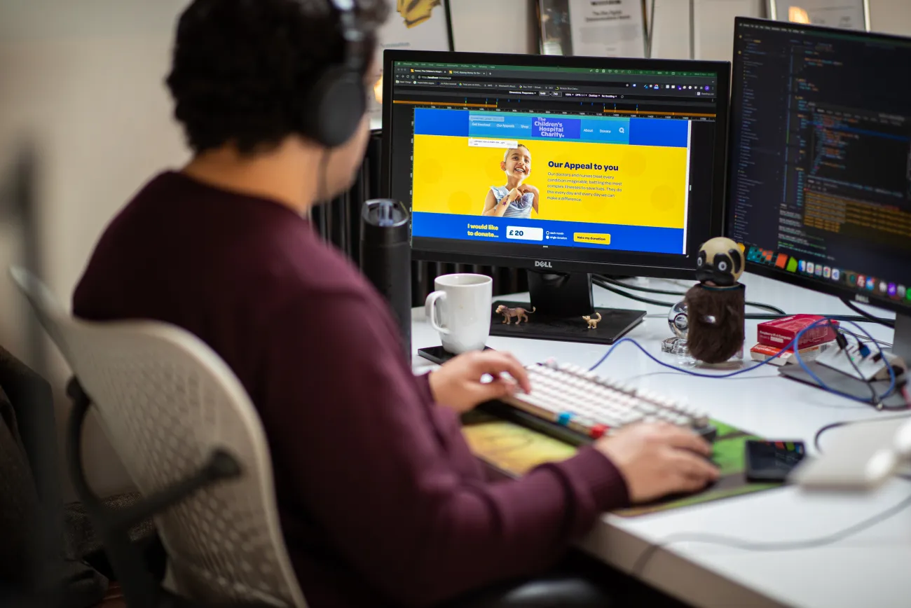 A developer sitting at a desk working on a website